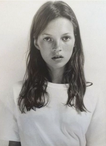 A plain white crew-neck tee, close portrait with hair loose over the shoulders.